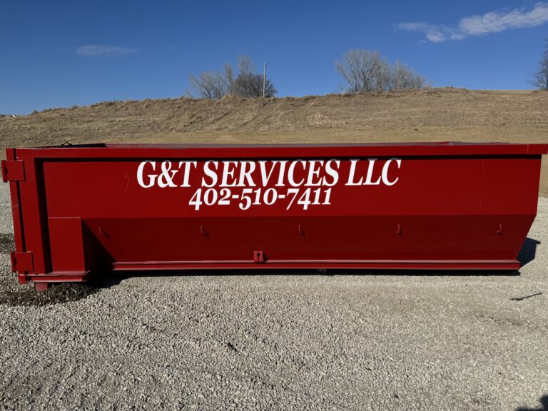 Rolloff dumpster on gravel ground with blue sky